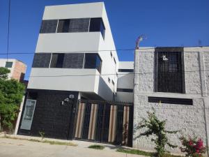 a white and black building on a street at Departamento Nuevo Suite Máster in Aguascalientes