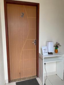 a wooden door with a number on it next to a desk at Apto Light pulse in Campos dos Goytacazes