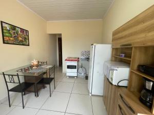 a small kitchen with a table and a refrigerator at Apto Light pulse in Campos dos Goytacazes
