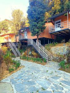 a building with stairs leading up to a house at Aaroham Resort Shimla ! Luxury Cottage by Aamod Group in Shimla