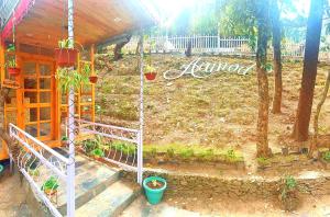 a garden with potted plants and a house at Aaroham Resort Shimla ! Luxury Cottage by Aamod Group in Shimla