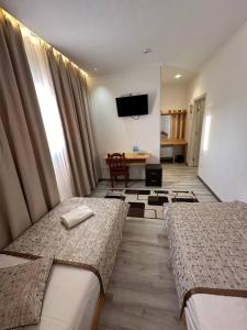 ein Hotelzimmer mit 2 Betten und einem TV in der Unterkunft Maryam hotel in Samarkand