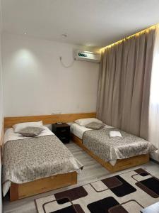 1 Schlafzimmer mit 2 Betten und einem Fenster in der Unterkunft Maryam hotel in Samarkand
