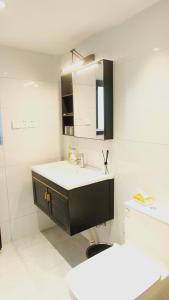 baño con lavabo y encimera blanca en Shanghai Hills & CoZy Polar B&B en Shanghái