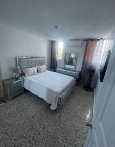 um quarto com uma cama grande e um espelho em Casa Blanca em Santo Domingo