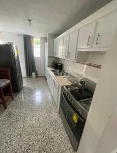 a kitchen with white cabinets and a stove top oven at Casa Blanca in Santo Domingo