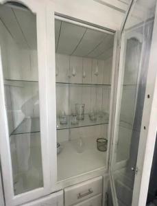 um armário branco com portas de vidro num quarto em Casa Blanca em Santo Domingo