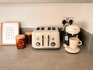 eine Küchentheke mit Kaffeemaschine und Kaffeemaschine in der Unterkunft Grand Union Apartment in Leicester