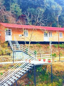 a house with a staircase in front of it at Aaroham Resort Shimla ! Luxury Cottage by Aamod Group in Shimla