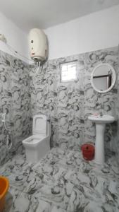 a bathroom with a toilet and a sink at Areca Adventures Family Cottage in Kushālnagar