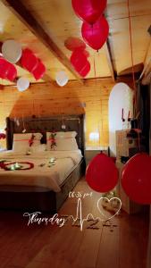 a bedroom with red and white balloons hanging from the ceiling at كوخ القمر in Taif