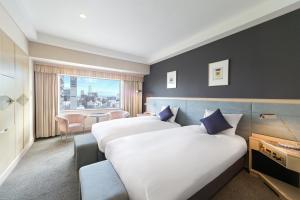 a hotel room with two beds and a window at Grand Mercure Sapporo Odori Park in Sapporo +79 photos
