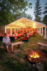 a group of people sitting under a tent next to a fire at Eco- Friendly Glamping Retreat in Salyer