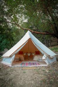 a white tent with a bed in a forest at Eco- Friendly Glamping Retreat in Salyer