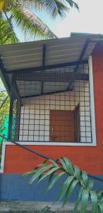 a building with a gate on the side of it at Areca Adventures Family Cottage in Kushālnagar