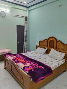 a bedroom with a wooden bed with purple sheets at Guru Kripa Guest House ( Home Stay ) in Ayodhya