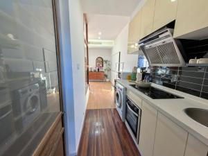 a kitchen with a sink and a washer and dryer at Shanghai Hills & Sunshine bnb in Shanghai