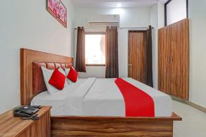 1 dormitorio con 1 cama con almohadas rojas en OYO Hotel Four S, en Haridwar