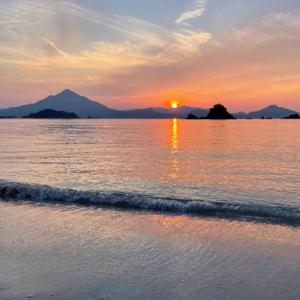 zachód słońca nad oceanem z plażą i górami w obiekcie Sea View Inn MURAMIYA w mieście Wada