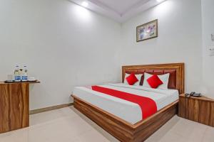 1 dormitorio con 1 cama grande con almohadas rojas en OYO Hotel Four S, en Haridwar