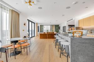 a kitchen and living room with a bar with stools at Modern King's Cross Apartments in London