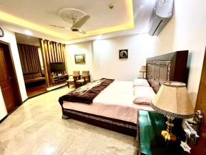 1 dormitorio con 1 cama y 1 mesa con lámpara en National Luxury Apartments - 2 Bed Room, en Lahore