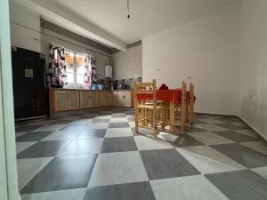una cocina con mesa y sillas en un suelo a cuadros en Appartement Oran en Orán
