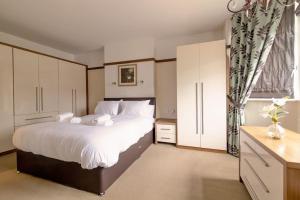 a bedroom with a large white bed and a window at Gilmoreton House in Leicester