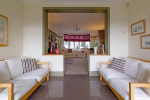 una sala de estar con sofás blancos y una sala de estar. en Gilmoreton House, en Leicester