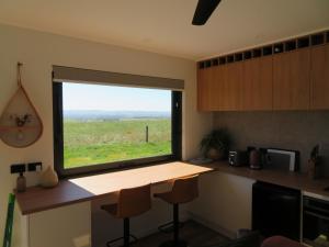 a kitchen with a window with a view of a field at Meeniyan360 in Meeniyan