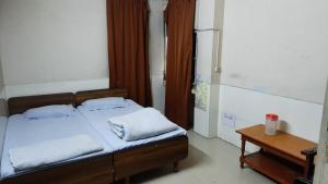 a bedroom with a bed with two pillows and a table at Hotel Prithviraj in Ajmer