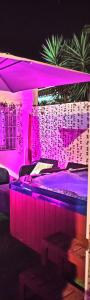 - une chambre avec des lumières violettes sur un lit dans l'établissement Malaga Chic jacuzzi y playa, à Malaga