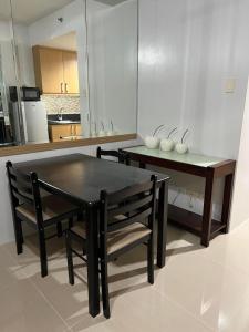 a kitchen with a table and a dining table and chairs at ARISE shell Residences in Manila