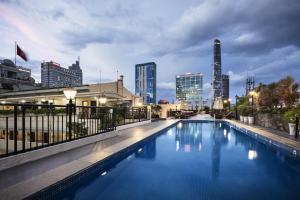 a large swimming pool with a city skyline in the background at Rex Hotel in Ho Chi Minh City