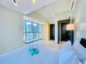 a bedroom with a white bed with a blue toy on it at Uptown Parksuites BGC in Manila