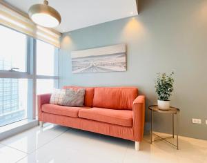a orange couch in a living room with a window at Uptown Parksuites BGC in Manila