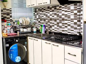 a kitchen with a dishwasher and a sink and a stove at Apartment B16 in Port Harcourt