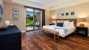 a bedroom with a bed and a sliding glass door at MAUNA KEA SUNRISE Distinguished 4BR KaMilo Home with Private Beach Pass in Waikoloa