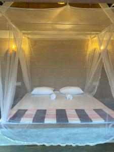 a bed with two pillows and a canopy at Summer Bell Midigama in Midigama East +30 photos
