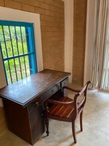 a wooden desk with a chair next to a window at Summer Bell Midigama in Midigama East