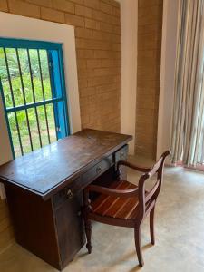a wooden desk with a chair next to a window at Summer Bell Midigama in Midigama