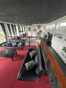 a living room with black leather chairs and a table at Ecolodge Loft in Oesterdeichstrich