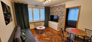 una sala de estar con un sofá y una mesa en Apartment on the San River, en Przemyśl