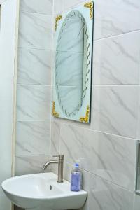 Apartment B16 في بورت هاركورت: حمام مع حوض ومرآة على الحائط
