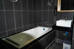 een badkamer met een ligbad en een wastafel bij ANGKOR SIVUTHA HOTEL in Siem Reap