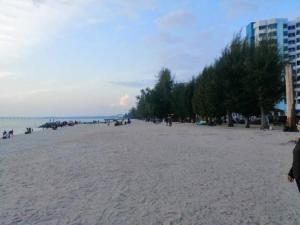 a group of people on a sandy beach at Auliya Homestay Melaka Seaview Pantai Puteri in Malacca