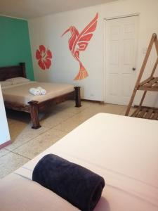 a room with two beds and a bird on the wall at Lost in San Jose Hostel & Suites in San José