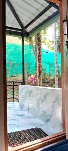 una porta aperta con vista sull'acqua di Areca Adventures Family Cottage a Kushalnagar