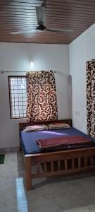 a bedroom with a wooden bed in a room at Areca Adventures Family Cottage in Kushālnagar