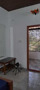 una camera con un tavolo in legno e una finestra di Areca Adventures Family Cottage a Kushalnagar